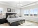 Bright main bedroom boasts large windows with neighborhood views, tray ceilings, and stylish decor at 17786 W 86Th Ln, Arvada, CO 80007