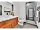 Modern bathroom featuring wood vanity, white countertops, toilet, and glass-enclosed shower with gray tile surround at 1100 S Gilpin St, Denver, CO 80210