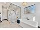 Modern bathroom features a glass-enclosed shower, free standing tub, and neutral finishes at 1100 S Gilpin St, Denver, CO 80210