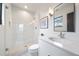 Bright bathroom featuring a walk-in shower with glass door and penny tile flooring and a bright white vanity at 1100 S Gilpin St, Denver, CO 80210