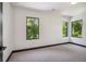 Bright bedroom features three large windows providing natural light and views of lush trees at 1100 S Gilpin St, Denver, CO 80210
