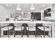 Modern kitchen boasts a large island with seating, pendant lights, and sleek black cabinetry at 1100 S Gilpin St, Denver, CO 80210