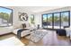 Bright living room with wood floors, white sofa, and sliding glass doors to balcony offering outdoor view at 1100 S Gilpin St, Denver, CO 80210