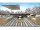 Outdoor patio with patio furniture set under a sun umbrella and black and white striped rug at 1100 S Gilpin St, Denver, CO 80210