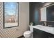 Chic powder room features unique wallpaper, black tile, and modern fixtures at 1100 S Gilpin St, Denver, CO 80210
