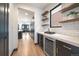 Wet bar features open shelving, wine fridge, countertop space, and access to the kitchen at 1100 S Gilpin St, Denver, CO 80210