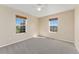 Bright bedroom with carpeted floors, light walls, and two large windows at 12784 Jasmine St # E, Thornton, CO 80602