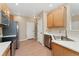 Well-lit kitchen with stainless steel appliances, wood floors, white countertops and wood cabinetry at 12784 Jasmine St # E, Thornton, CO 80602