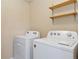 Laundry room with shelving and white washer and dryer at 12784 Jasmine St # E, Thornton, CO 80602