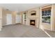 Neutral toned living room features fireplace, large windows for natural light, and comfortable seating area at 12784 Jasmine St # E, Thornton, CO 80602