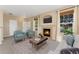 Cozy living room featuring a fireplace with TV, plush seating, large windows, and neutral tones at 12784 Jasmine St # E, Thornton, CO 80602