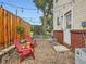 Cozy backyard patio with gravel, string lights, red chairs, and a wooden privacy fence at 6065 Wadsworth Blvd # A, Arvada, CO 80003