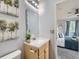Clean bathroom featuring a wood vanity, modern sink, and a view into an adjacent bedroom at 6065 Wadsworth Blvd # A, Arvada, CO 80003