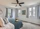 Cozy bedroom with plush carpet, multiple windows with curtains, ceiling fan, and a comfortable bed at 6065 Wadsworth Blvd # A, Arvada, CO 80003