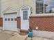 Charming front entrance featuring a brick facade, quaint white door, and a well-maintained garage at 6065 Wadsworth Blvd # A, Arvada, CO 80003