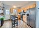 Bright kitchen with wood cabinets, stainless appliances, and eat-in breakfast bar at 6065 Wadsworth Blvd # A, Arvada, CO 80003