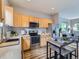 Well-lit kitchen featuring wood cabinetry, stainless steel appliances, and an eat-in dining table at 6065 Wadsworth Blvd # A, Arvada, CO 80003
