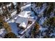 Winter aerial view of the home showcasing its setting among snow-covered grounds and surrounding pine trees at 1580 Santa Fe Mountain Rd, Evergreen, CO 80439