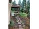 Backyard area featuring a stone pathway, a deck with seating, and a lush wooded setting at 1580 Santa Fe Mountain Rd, Evergreen, CO 80439