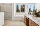 Bright bathroom featuring a shower, a soaking tub, double sinks, wood cabinets and a large window at 1580 Santa Fe Mountain Rd, Evergreen, CO 80439