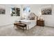 Bright bedroom features large windows, neutral carpet, and a tufted headboard, complemented by floral artwork at 1580 Santa Fe Mountain Rd, Evergreen, CO 80439