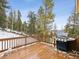 Inviting wood deck area features a gas grill and serene views of the surrounding landscape with snowy mountain backdrop at 1580 Santa Fe Mountain Rd, Evergreen, CO 80439