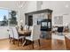 Open concept dining room with mountain views, wood floors, and a fireplace connecting to the living room at 1580 Santa Fe Mountain Rd, Evergreen, CO 80439