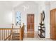 Inviting entryway featuring wood flooring, a decorative mirror, and natural light from the adjacent window at 1580 Santa Fe Mountain Rd, Evergreen, CO 80439