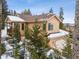 Charming two-story home featuring a covered porch, attached garage, and beautiful forest surround at 1580 Santa Fe Mountain Rd, Evergreen, CO 80439