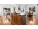 Bright kitchen with a cooktop island, barstool seating, and hardwood floors at 1580 Santa Fe Mountain Rd, Evergreen, CO 80439