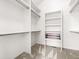 A walk-in closet featuring all-white walls and shelves, with a neutral carpet and a brown shoe rack at 1580 Santa Fe Mountain Rd, Evergreen, CO 80439