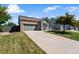 Exterior view of home with a well-manicured lawn, long driveway, brick accents, and lovely shade tree at 19771 E Wesley Pl, Aurora, CO 80013