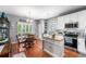 Bright kitchen with white cabinets, stainless steel appliances, kitchen island and hardwood floors at 19771 E Wesley Pl, Aurora, CO 80013
