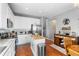 Bright kitchen featuring white cabinets, stainless steel appliances, and a central butcher block island at 19771 E Wesley Pl, Aurora, CO 80013
