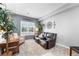 Cozy sitting room featuring a leather loveseat, an accent chair, and natural light from the window at 19771 E Wesley Pl, Aurora, CO 80013