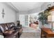 Inviting sitting room with a leather loveseat, adjacent to another room through double doors at 19771 E Wesley Pl, Aurora, CO 80013