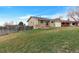 Tan home featuring a paved driveway, two-car garage, and a large front yard at 1882 S Zinnia Way, Lakewood, CO 80228