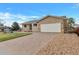 Tan home featuring a paved driveway, two-car garage, and front lawn with river rock at 1882 S Zinnia Way, Lakewood, CO 80228