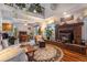 Cozy living room featuring a brick fireplace, wood floors, and bright dining area at 9365 W 80Th Pl # C, Arvada, CO 80005