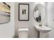 Powder room featuring pedestal sink, framed artwork, and natural lighting at 7214 S Shady Grove Ct, Aurora, CO 80016