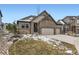 Charming home with a three-car garage, stone accents, and winter-ready landscaping at 7214 S Shady Grove Ct, Aurora, CO 80016