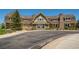 Exterior of community clubhouse featuring stone accents, decorative porches, and mature trees at 7214 S Shady Grove Ct, Aurora, CO 80016