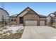 Beautiful home with a stone facade, complemented by a spacious driveway and manicured lawn at 7214 S Shady Grove Ct, Aurora, CO 80016