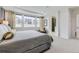 Bright main bedroom featuring large windows, tray ceiling, and ensuite bathroom access at 7214 S Shady Grove Ct, Aurora, CO 80016