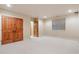 Large finished basement space with double wood doors, neutral carpet, and a window at 1907 S Columbine St, Denver, CO 80210