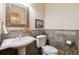 Elegant powder room featuring decorative mirror, pedestal sink, and stylish wall tile at 1907 S Columbine St, Denver, CO 80210