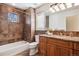 Warm bathroom featuring a tub and shower combination, earth toned tiles, and granite topped vanity at 1907 S Columbine St, Denver, CO 80210