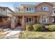 Charming brick home featuring a covered front porch, manicured lawn, and inviting curb appeal at 1907 S Columbine St, Denver, CO 80210