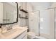 Stylish bathroom with a white tile shower, modern vanity, and patterned wallpaper at 3643 White Rose Loop, Castle Rock, CO 80108