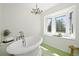 Bright bathroom features a freestanding tub situated beneath a large bay window with window seat at 133 Mine Ln, Boulder, CO 80302
